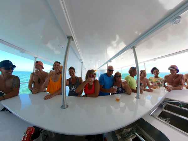 people gathered around a bar on a yacht