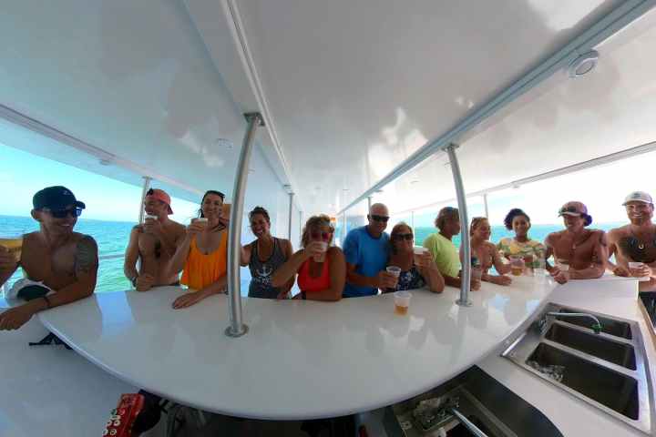 people gathered around a bar on a yacht